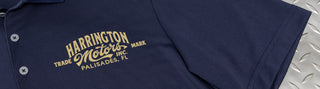 navy golf shirt embroidered with personalized Motor Shop design, on diamond plate work table