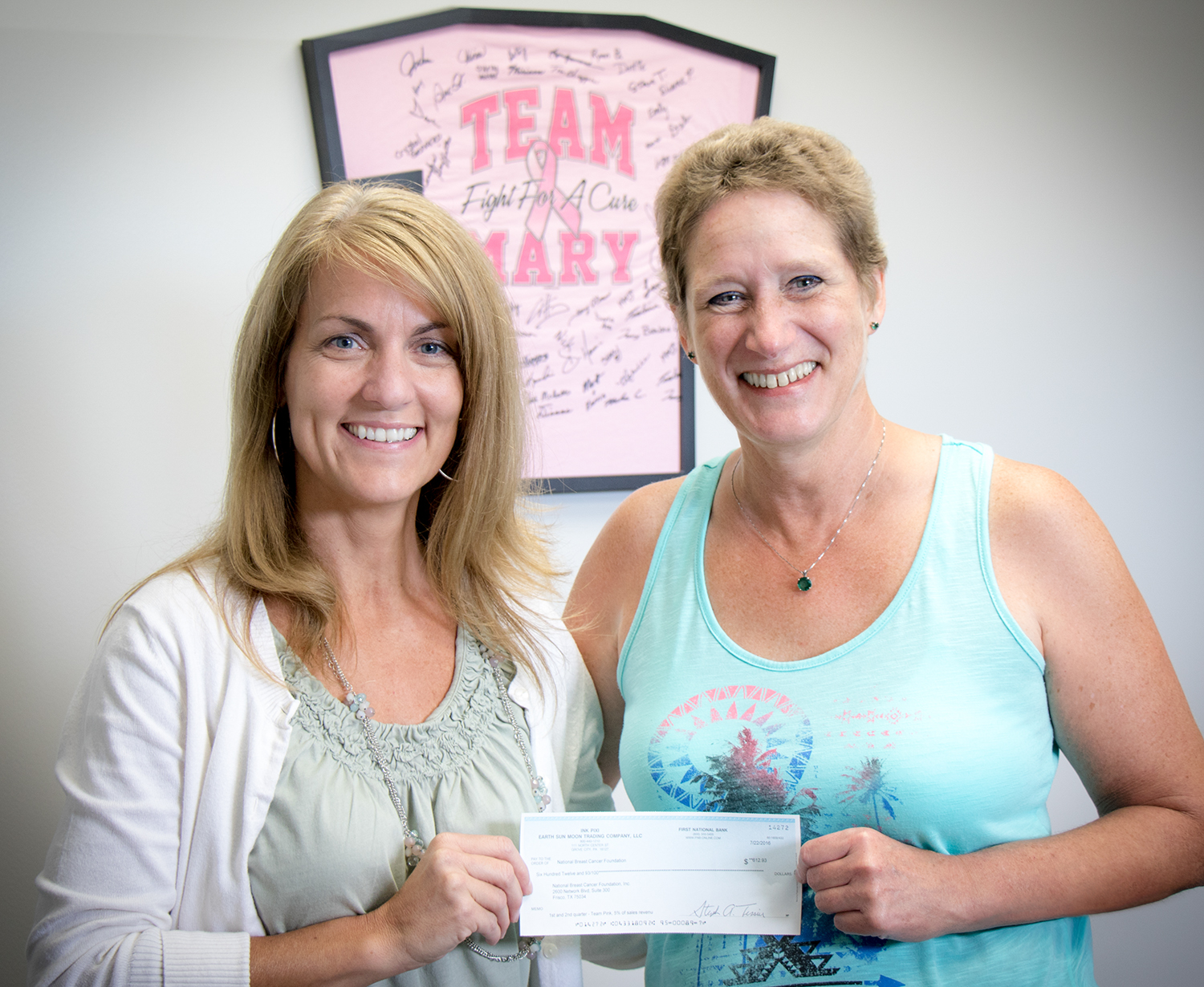 Kristie and Mary proudly displaying our first donation to the NBCF
